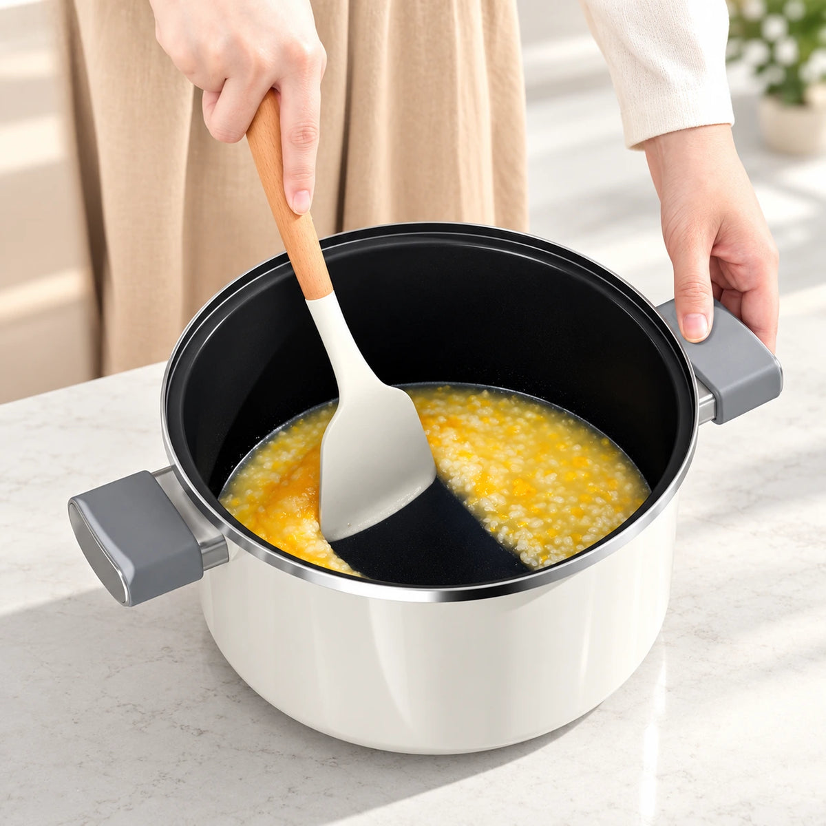 Smooth black enamel interior of the Pearl White pot, shown with corn porridge and a soft spatula