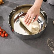 Hands kneading dough in a deep polished stainless steel bowl