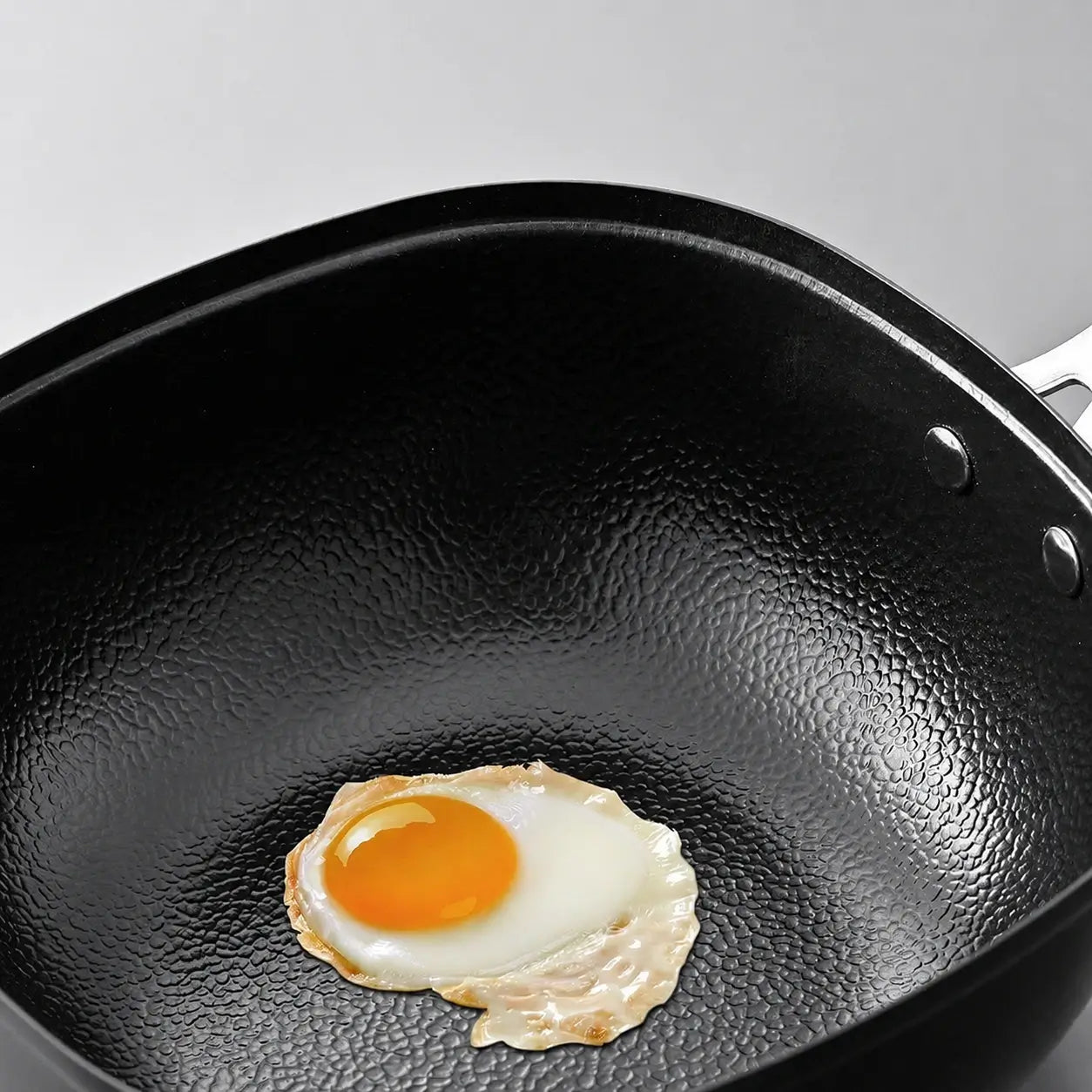Egg cooking on the hammered surface with a small amount of oil