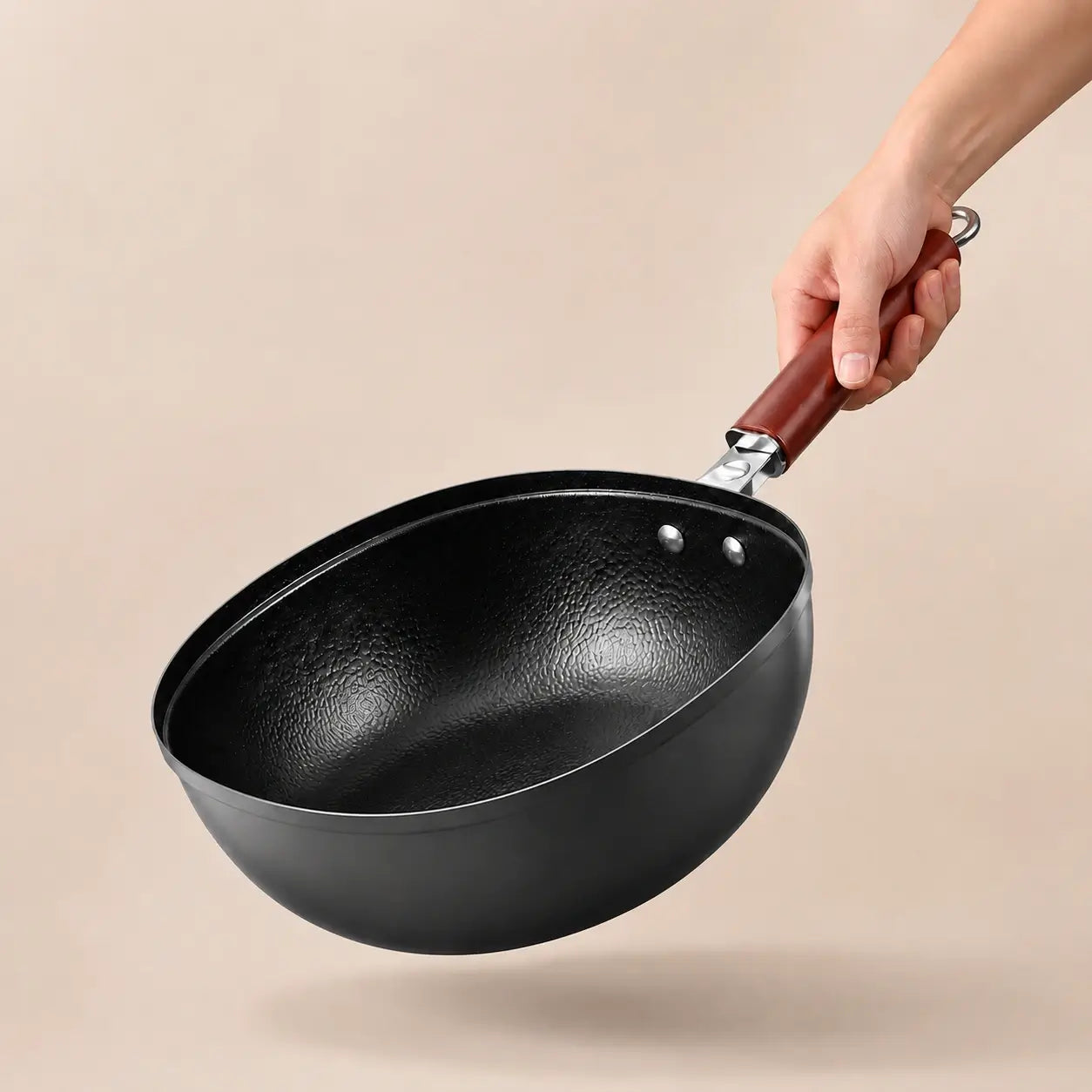 Hero — angled view of the deep hammered titanium iron pan