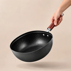 Hero — angled view of the deep hammered titanium iron pan