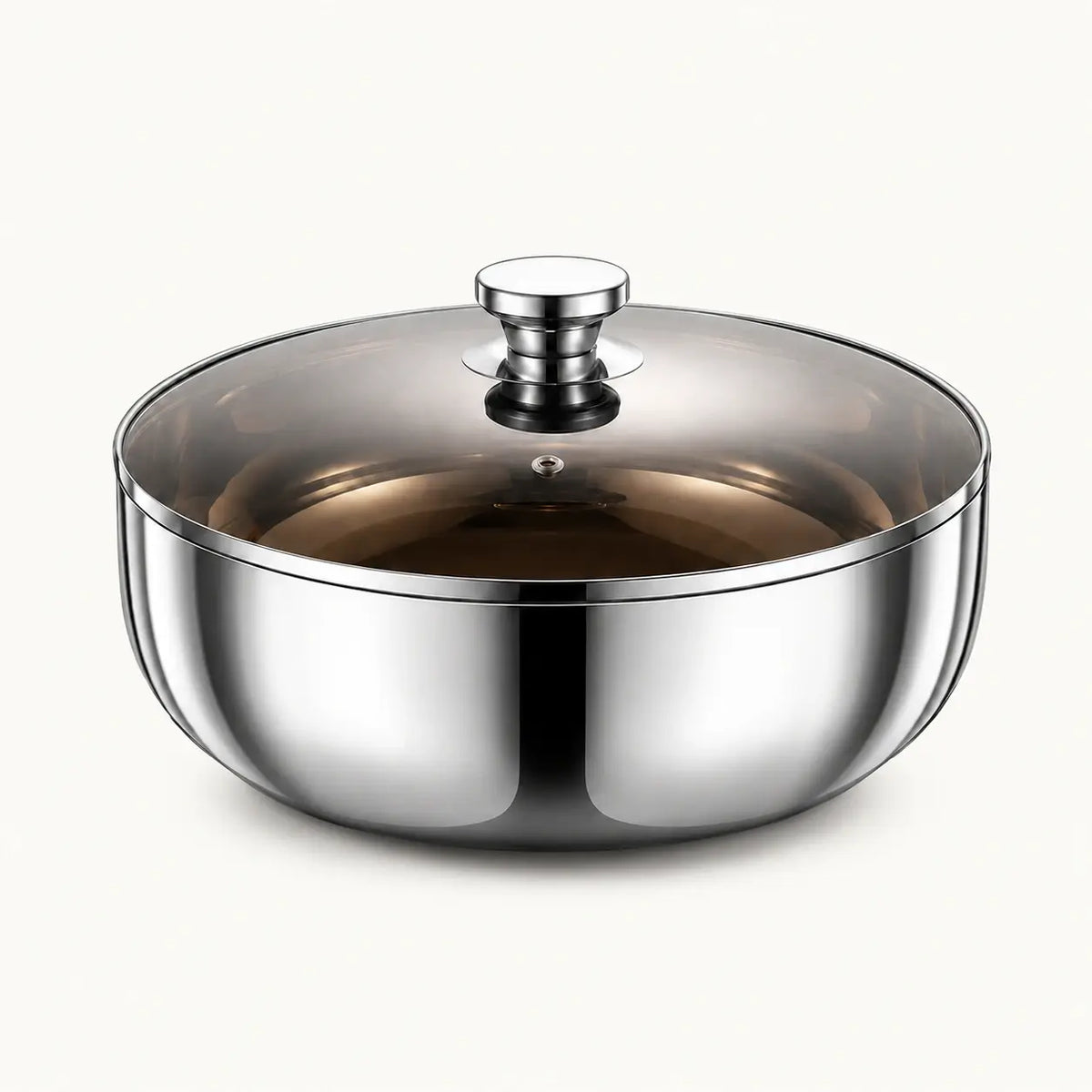 Polished stainless steel mixing bowl with smoky glass lid on a white background