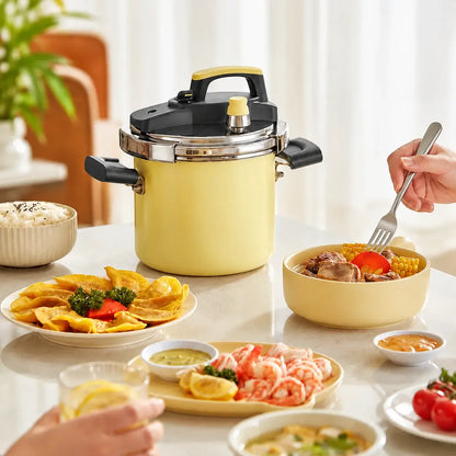 Yellow pressure cooker on a dining table beside a selection of home-style dishes.