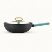 Full side view of the black pan with blue-green handle and glass lid