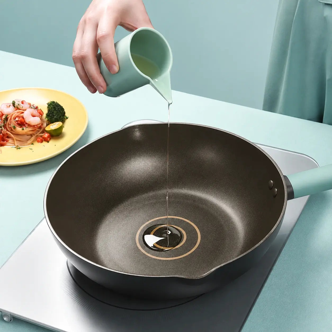 Cooking oil being poured into the two guide rings inside the pan