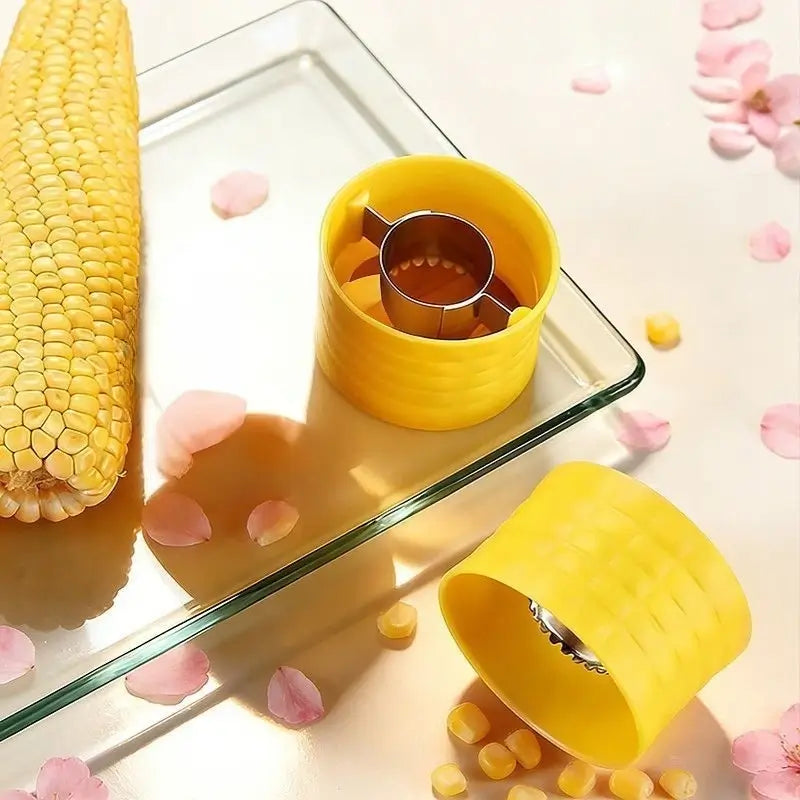 Compact yellow manual corn stripper beside a cob