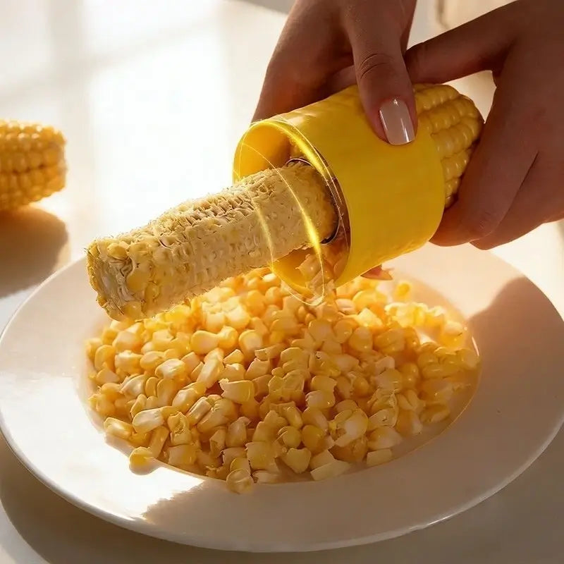 Corn kernels falling into a bowl as the tool moves along the cob